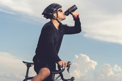 Fahrradfahrer trinkt Wasser während der Fahrt