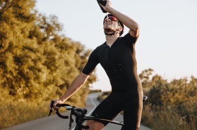 Radfahrer duscht sich mit Wasser